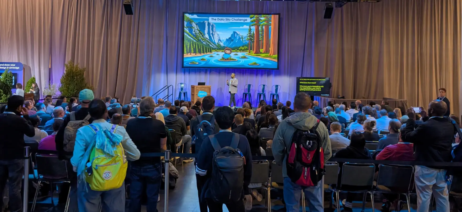 Packed Dreamforce session audience watching a speaker on stage